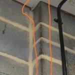 Mice smear marks on a concrete wall revealing a hole on top